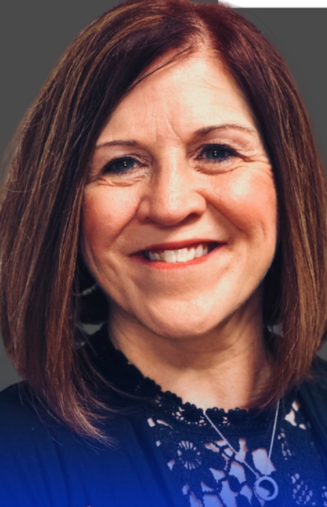 a smiling white woman with shoulder length reddish brown hair and blue blouse
